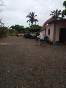 PedregalCabañas Martina Surf Playa Guanico的骑着自行车在房子前的人