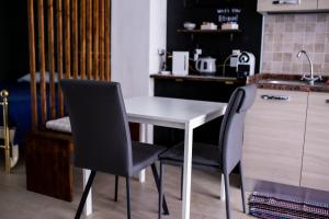 博洛尼亚Bologna Travel Suite的厨房配有白色的桌子和两把椅子