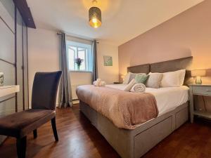 诺丁汉The Orchid-Central Beeston-Private Apartment-SmartTV-Free Wi-Fi-Tram-Parking的卧室配有床、椅子和窗户。