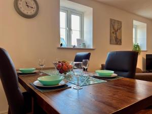 诺丁汉The Orchid-Central Beeston-Private Apartment-SmartTV-Free Wi-Fi-Tram-Parking的餐桌、椅子和墙上的时钟