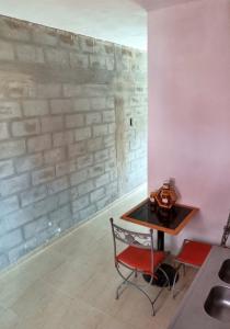 ChamicalMonoambientes Chamical的砖墙房间里一张桌子和一把椅子
