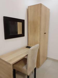 伊凯贾Zek’s Place的一张带椅子的木桌和墙上的电视