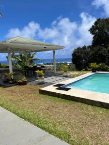 阿瓦鲁阿Tereora Heights Pool Retreat的一个带凉亭的游泳池以及大海