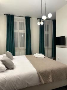 波兹南Expo Apartments的一间卧室配有一张带绿色窗帘的大床
