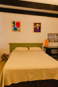 棕榈滩Villa Bougainvillea Aruba Rumba Suite的卧室配有一张床,墙上挂有两幅画