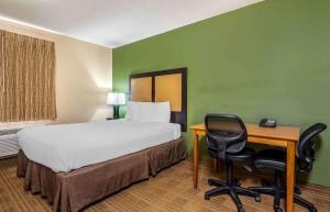 埃文斯维尔美国长住酒店 - 埃文斯维尔 - 东的客房设有1张床、1张桌子、1张床和1把椅子