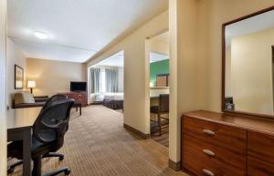 弗洛伦斯Extended Stay America Select Suites - Cincinnati - Florence - Meijer Dr的酒店客房设有书桌和卧室。