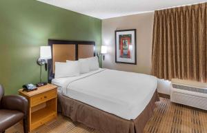 奥本希尔斯底特律奥本山大学路美国长住酒店的酒店客房带一张大床和一把椅子