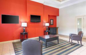 欧文美国长住酒店 - 达拉斯 - DFW机场北的客厅设有红色的墙壁和桌椅