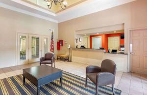 欧文美国长住酒店 - 达拉斯 - DFW机场北的客厅配有椅子、桌子和国旗