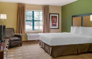 欧文美国长住酒店 - 达拉斯 - DFW机场北的配有一张床和一把椅子的酒店客房