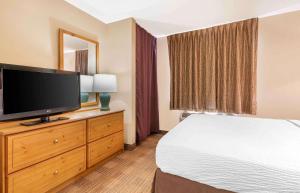 欧文美国长住酒店 - 达拉斯 - DFW机场北的配有一张床和一台平面电视的酒店客房