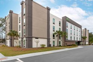 布拉夫顿Extended Stay America Premier Suites - Bluffton - Hilton Head的街道前方棕榈树的大型办公楼