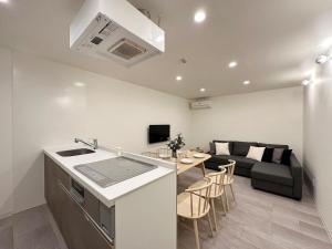 ŌsukachōbHOTEL Nikke - Apt for 10Ppl Ideal for Big Group in City Center的厨房以及带沙发和桌子的客厅。