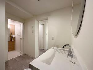 ŌsukachōbHOTEL Nikke - Apt for 10Ppl Ideal for Big Group in City Center的白色的浴室设有水槽和镜子