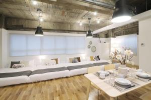 广岛bHOTEL Nikke - 1BR Apt for 10ppl near Hondori Shopping的一张大白色沙发,位于带桌子的房间
