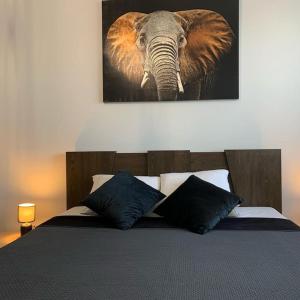 罗兹Central Park Apartment的卧室配有一张挂在墙上的大象画床。