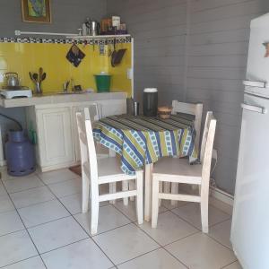 Puerto LibertadEspacio Benignia的厨房配有桌子和两把椅子、一张桌子和一张桌子。