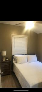 西点Louisiana State Cabin的卧室配有白色的床和床头柜