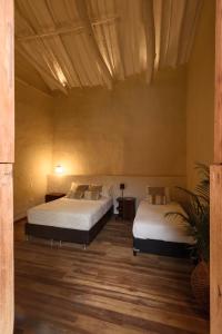 巴里查拉CASA JUANA BARICHARA的配有2张床的木地板客房