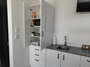 One Tree PointMarina Views的厨房配有白色橱柜和水槽
