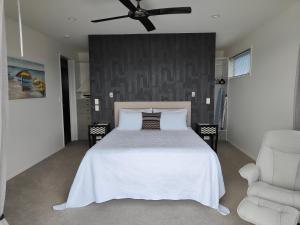 One Tree PointMarina Views的卧室配有白色的床和吊扇