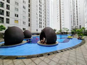雅加达Apt Bassura Studio Tower F w/ Pool, Wi-Fi & Netflx的一座城市里带三个大球的游泳池