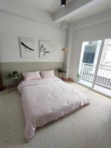 合艾Red panda@hatyai Leegarden 200m的白色卧室配有一张带粉红色床单的大床