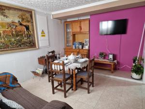 丘利利亚Casa Rural La Replaceta的一间设有一张桌子和紫色墙壁的用餐室