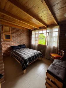 奥塔瓦洛Cabañas Tecla María的一间卧室设有一张床和砖墙