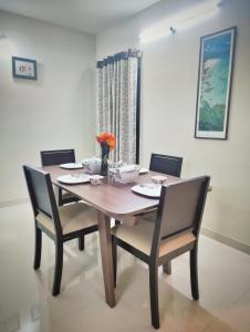 那格浦尔Symphony Apartments at MIHAN Nagpur的餐桌、四把椅子和一张木桌