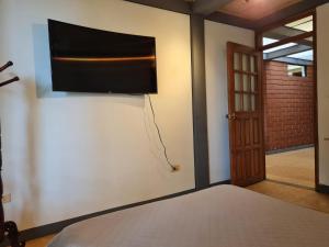 VillamaríaCasa Vélez: habitación natural的卧室配有一张床和壁挂式平面电视。