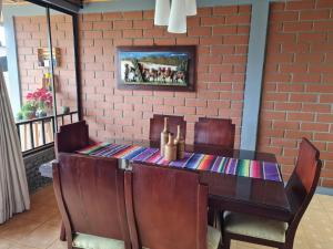 VillamaríaCasa Vélez: habitación natural的餐桌、椅子和砖墙