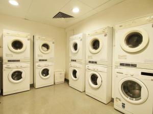 香港218 Apartment的洗衣房配有4台洗衣机和烘干机