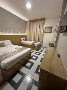 第波罗Bamboo Garden Bussiness Inn的酒店客房配有两张床和一张书桌