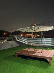 蔚山Jinistay #Netflix #Oceanview #private barbeque facility #1pm checkout的草场上带雨伞的野餐桌