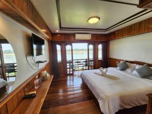黎府Suksomboonhotel的一间卧室配有一张大床和一台电视。