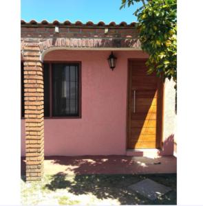 科斯塔阿苏尔Lo de Sandra的粉红色的房子,有门和窗户