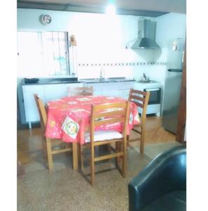 科斯塔阿苏尔Lo de Sandra的厨房配有桌椅和红色桌布