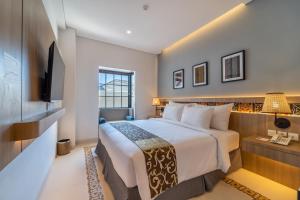 龙目岛库塔MONTANA @OCEANSIDE MANDALIKA的一间酒店客房,配有一张床和一台电视