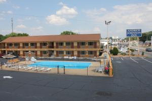 格林维尔Andrew Johnson Inn的停车场前设有游泳池的酒店