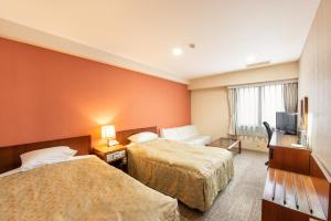 宇都宫HOTEL NEWITAYA的酒店客房设有两张床和电视。