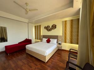 康格拉Hotel River Retreat的一间卧室配有一张床和一张红色的沙发