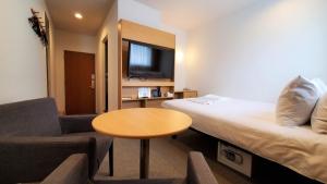 青森Hotel Passage 2的酒店客房配有床、桌子和沙发。