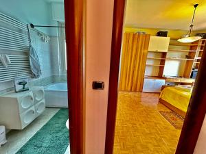 菲亚诺Finestra sulle Alpi e Golf的客房设有带浴缸的浴室和一间卧室。