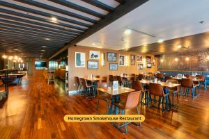 迪拜温德姆迪拜码头酒店的餐厅铺有木地板,配有桌椅