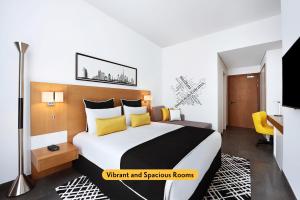 迪拜迪拜温德姆特瑞普酒店的一间卧室配有一张带黄色枕头的大床