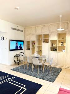迪拜Charming spacious studio apartment in the heart of JBR By SWEET HOMES的客厅配有桌椅和电视。