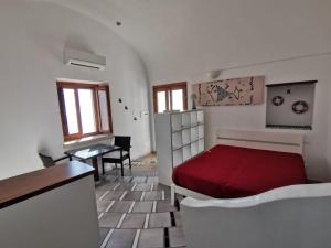 弗洛里Il Nido Del Falco - Art house with terrace and sea view的一间卧室配有红色的床和一张桌子