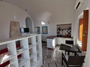 弗洛里Il Nido Del Falco - Art house with terrace and sea view的厨房以及带柜台和桌子的用餐室